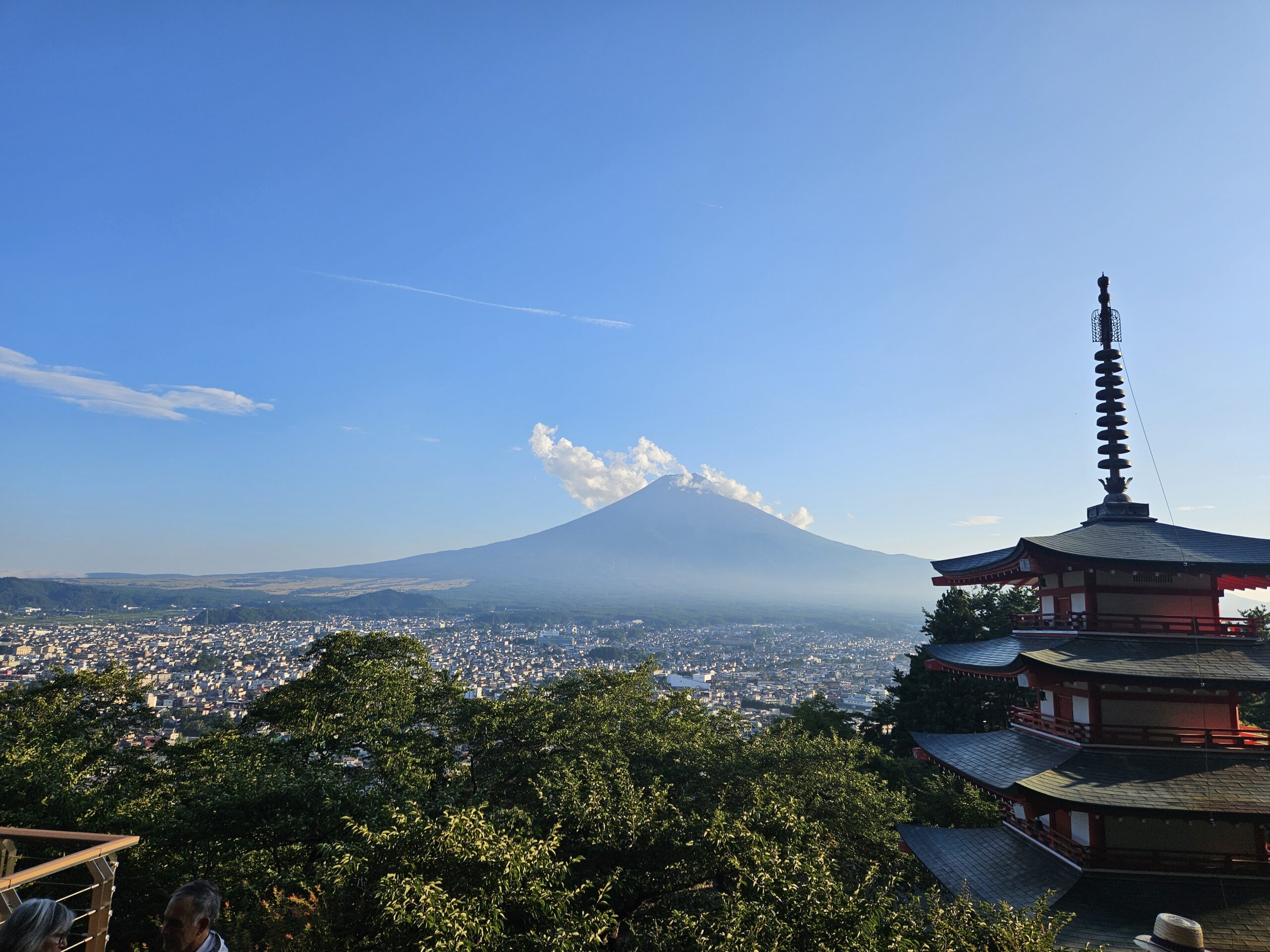 Chureito Pagoda overlooking Fujiyoshida with Mount Fuji rising in the distance beneath a clear blue sky.
